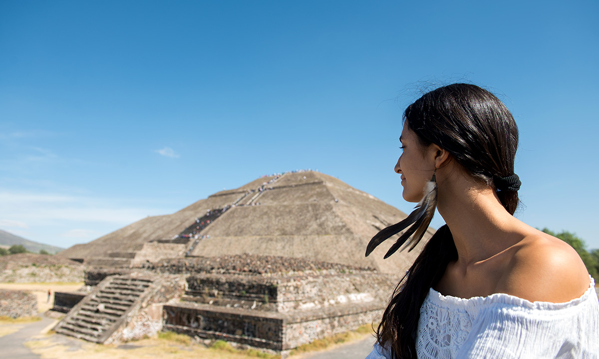 Mujer viendo ruinas mayas.