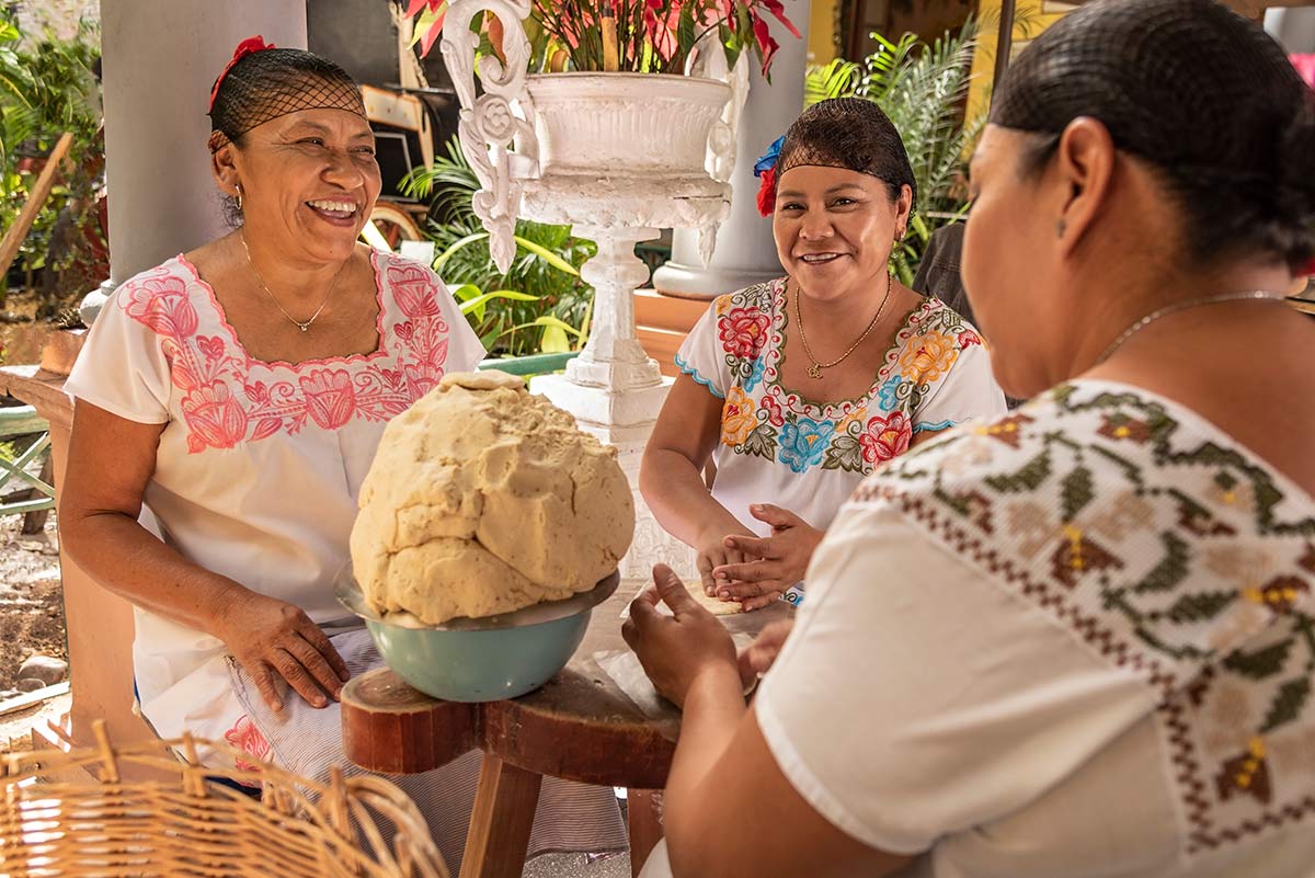 Mujeres teniendo una agradable conversación mientras hacen tortillas